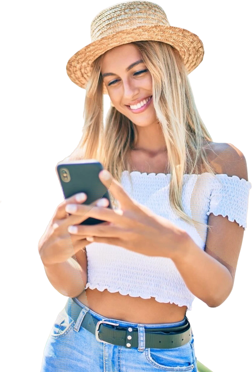 A smiling traveller messages a New Zealand or Australian tour operator from her phone, outdoors in the sun